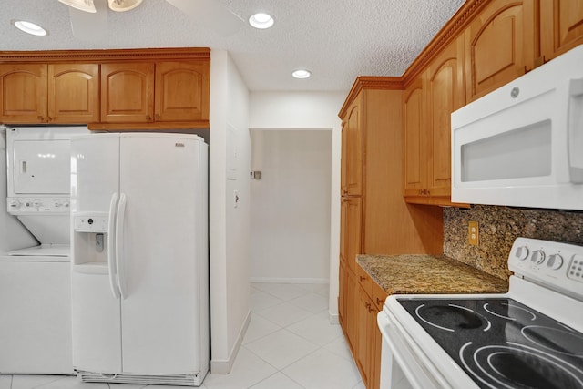 1260 NW 20th Ave Unit 203, Delray Beach, FL 33445 - kitchen featuring light tile patterned floors, stacked washer and clothes dryer, stone countertops, white appliances, and backsplash