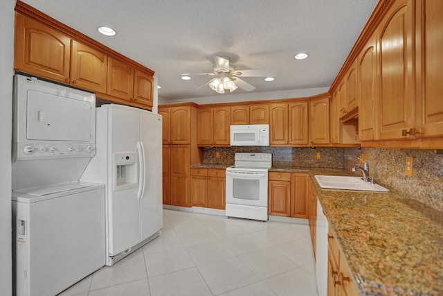 1260 NW 20th Ave Unit 203, Delray Beach, FL 33445 - kitchen featuring a sink, decorative backsplash, a ceiling fan, white appliances, and stacked washer and dryer