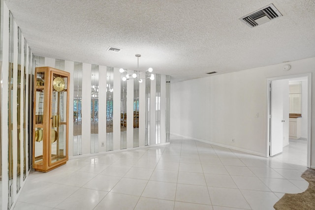 1260 NW 20th Ave Unit 203, Delray Beach, FL 33445 - unfurnished room with a notable chandelier, a textured ceiling, visible vents, and baseboards