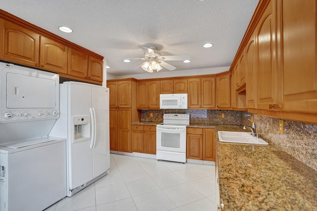 1260 NW 20th Ave Unit 203, Delray Beach, FL 33445 - kitchen featuring stacked washer and dryer, white appliances, brown cabinets, ceiling fan, and a sink