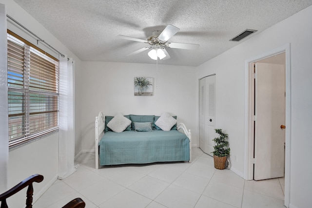1260 NW 20th Ave Unit 203, Delray Beach, FL 33445 - bedroom featuring light tile patterned flooring, a closet, a ceiling fan, visible vents, and a textured ceiling