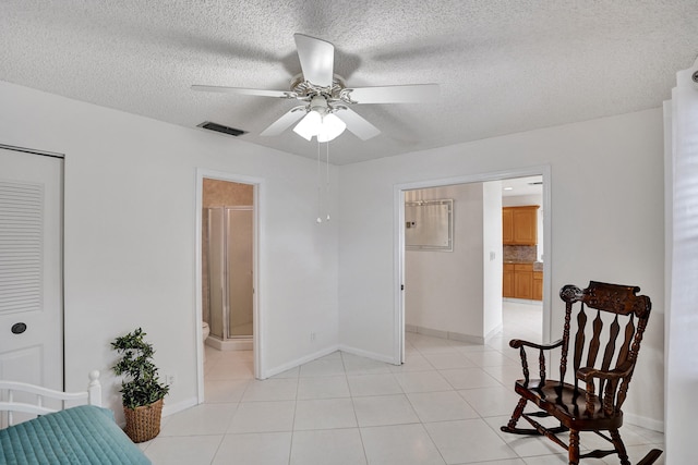 1260 NW 20th Ave Unit 203, Delray Beach, FL 33445 - bedroom with light tile patterned flooring, a textured ceiling, visible vents, and baseboards