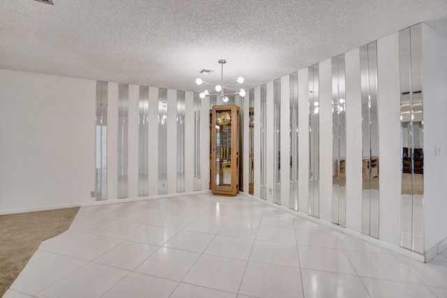 1260 NW 20th Ave Unit 203, Delray Beach, FL 33445 - unfurnished dining area with an inviting chandelier, wallpapered walls, baseboards, visible vents, and a textured ceiling