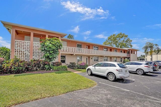 1260 NW 20th Ave Unit 203, Delray Beach, FL 33445 - view of front of property with uncovered parking, a front yard, and stucco siding