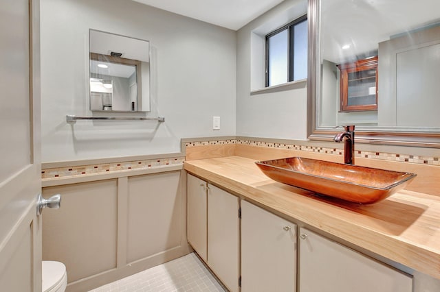 bathroom with tile patterned flooring, vanity, and toilet