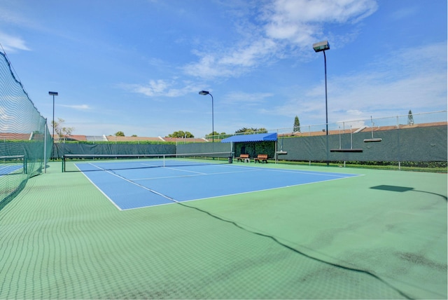 view of tennis court with basketball hoop