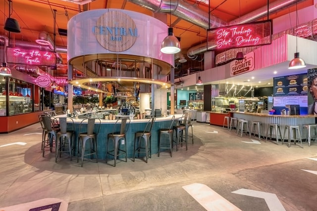 bar with concrete floors and decorative light fixtures