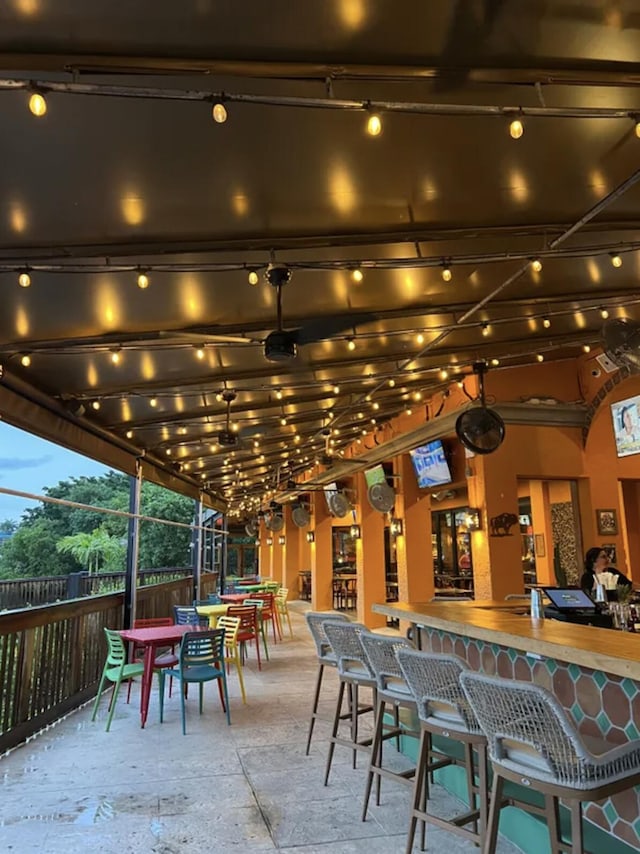 patio terrace at dusk featuring a bar