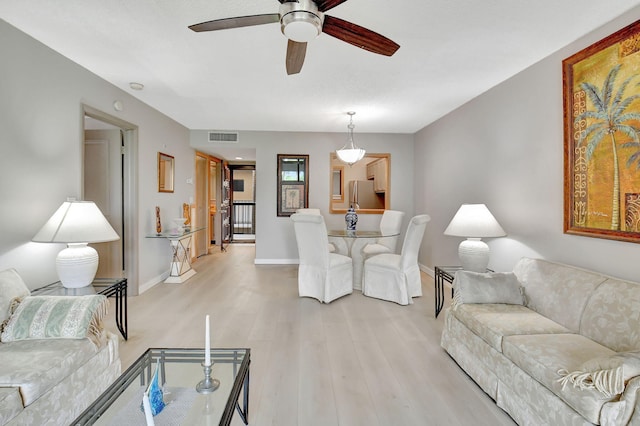 living room with ceiling fan and light wood-type flooring