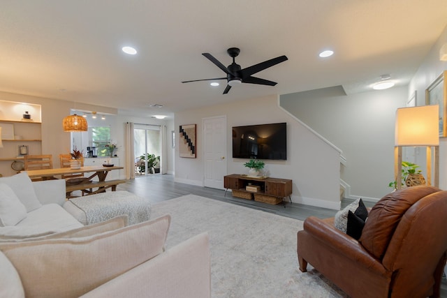 living room with wood-type flooring and ceiling fan