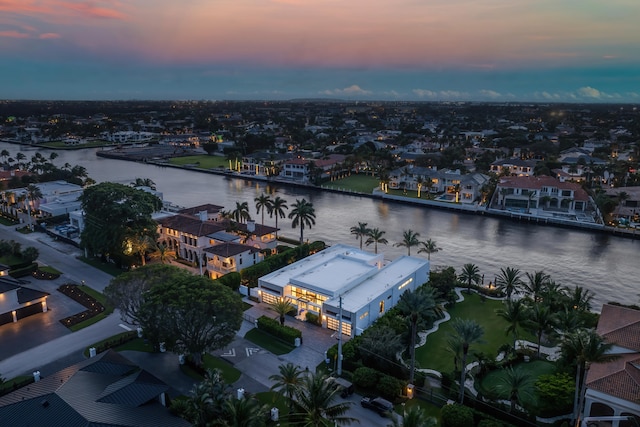 aerial view at dusk featuring a water view