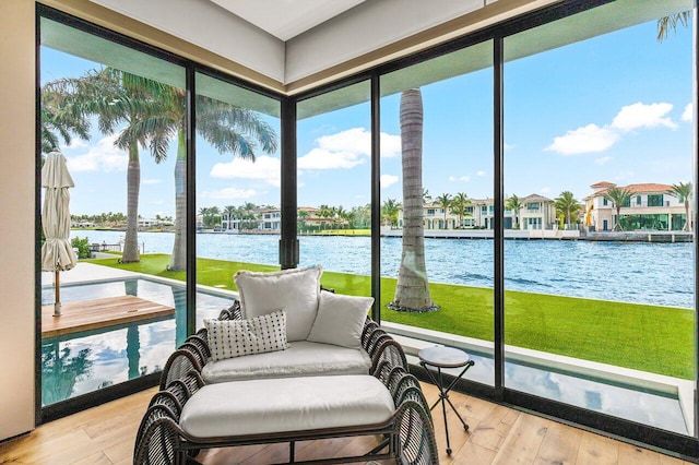 sunroom featuring a water view