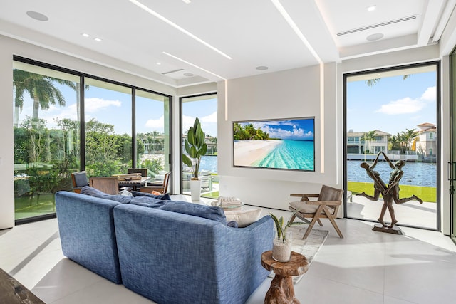 living room with a healthy amount of sunlight, light tile patterned floors, and a water view