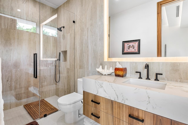 bathroom with tile walls, walk in shower, vanity, and toilet