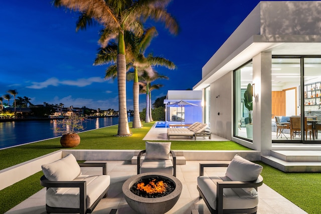 view of patio featuring a water view and an outdoor living space with a fire pit