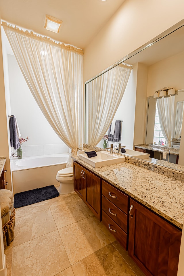 bathroom featuring vanity, tile patterned flooring, a washtub, and toilet