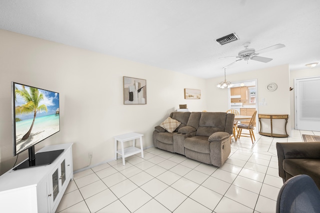 tiled living room with ceiling fan with notable chandelier