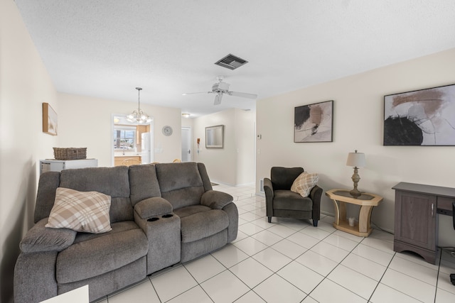 tiled living room with a textured ceiling and ceiling fan with notable chandelier