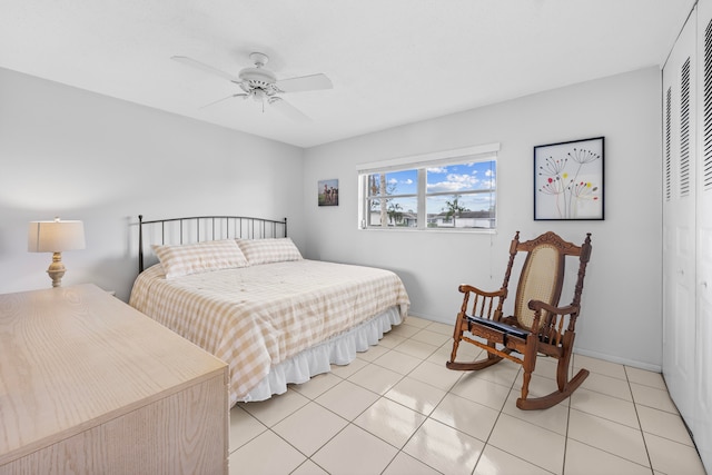 bedroom with a closet, light tile patterned floors, and ceiling fan