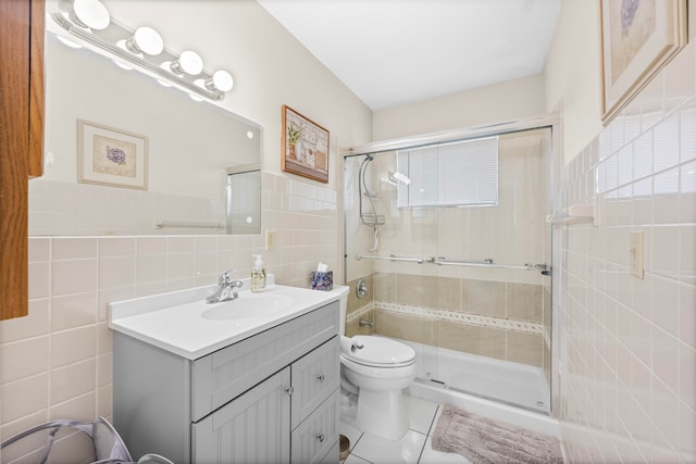 bathroom with vanity, an enclosed shower, tile patterned floors, toilet, and tile walls