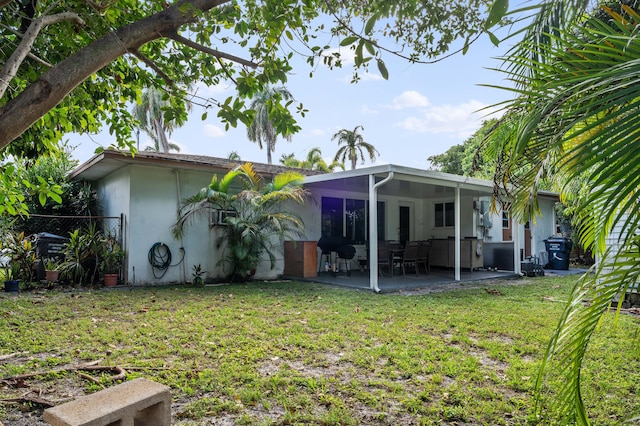 rear view of property featuring a patio area and a lawn