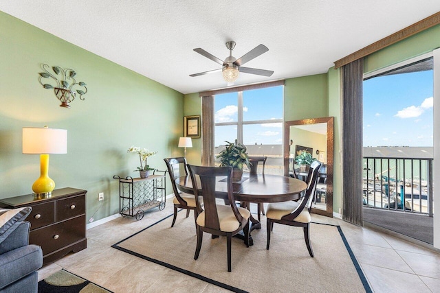 dining room with light tile patterned flooring, ceiling fan, and a textured ceiling