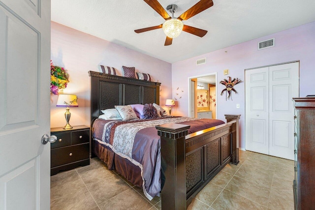 bedroom featuring light tile patterned flooring, a textured ceiling, ceiling fan, and a closet