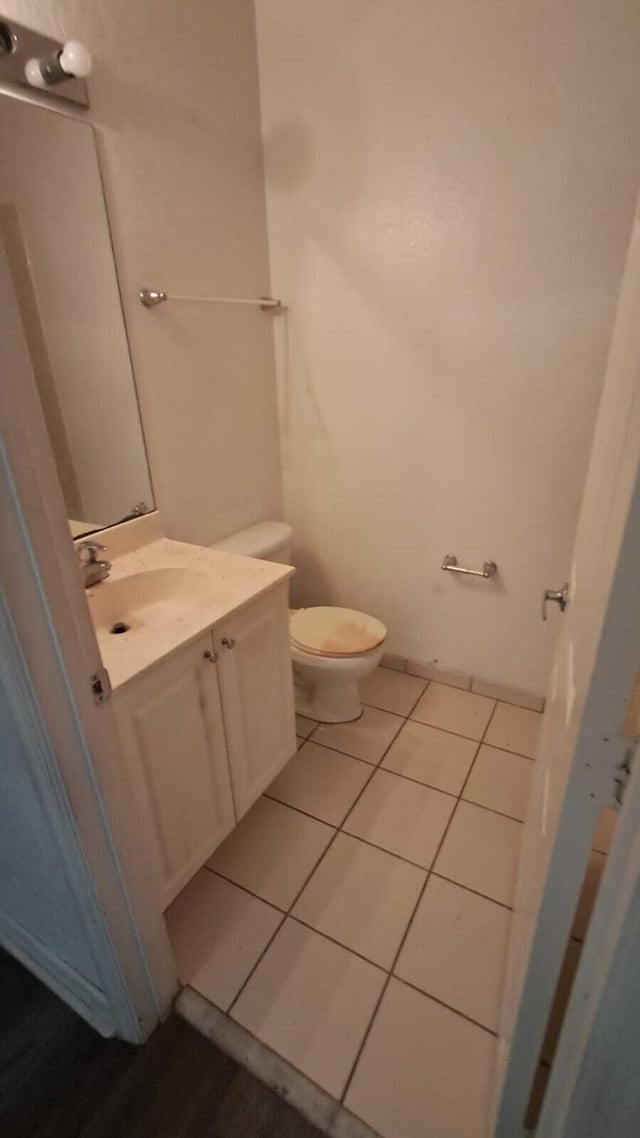 bathroom featuring tile patterned flooring, vanity, and toilet