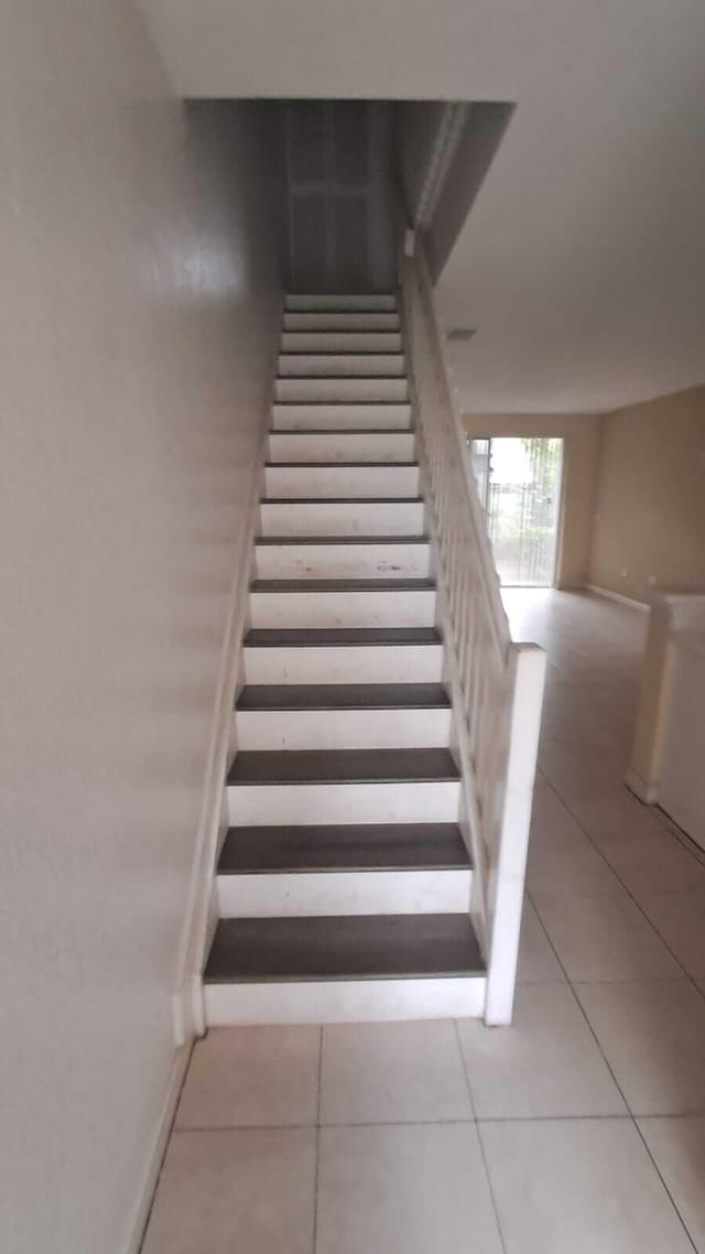 stairway with tile patterned floors