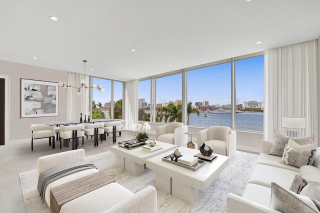 carpeted living room with plenty of natural light, floor to ceiling windows, a water view, and an inviting chandelier