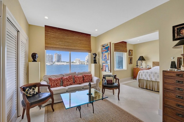 tiled bedroom featuring multiple windows, a closet, and a water view