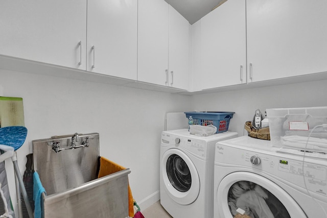 laundry room with washer and dryer and cabinets