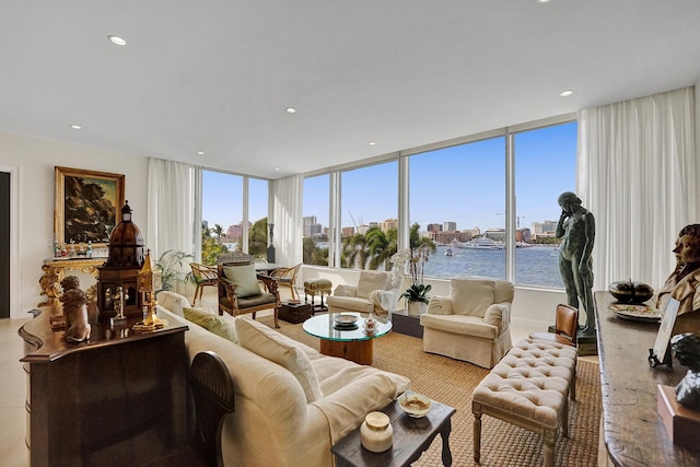 living room with expansive windows, a water view, and a wealth of natural light