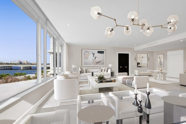 living room with a water view and a chandelier