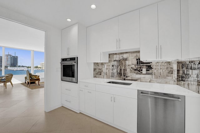 kitchen with white cabinetry, sink, a water view, and stainless steel appliances