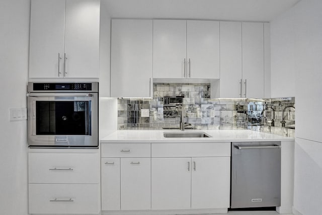 kitchen featuring white cabinetry, sink, appliances with stainless steel finishes, and tasteful backsplash