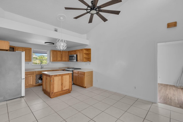 kitchen with stainless steel appliances, a kitchen island, light countertops, open shelves, and decorative light fixtures