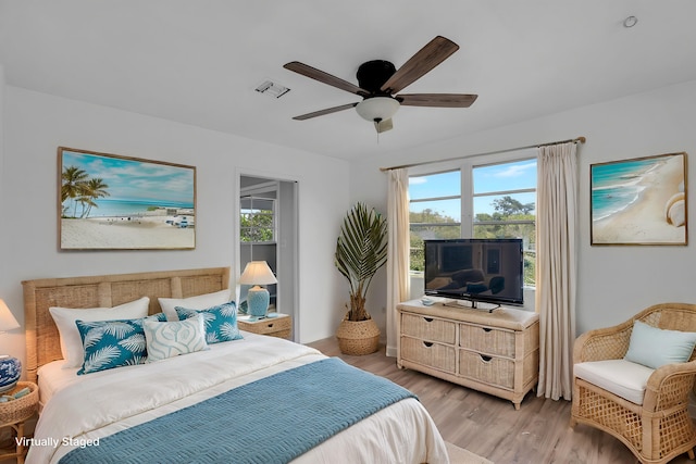 bedroom featuring a ceiling fan, multiple windows, visible vents, and light wood-style floors