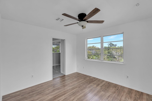 empty room with light wood-style flooring, visible vents, and a ceiling fan