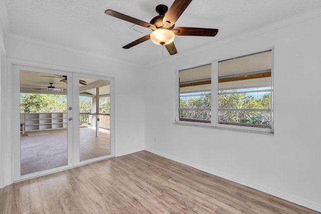 unfurnished room featuring light wood-style floors, crown molding, and a wealth of natural light