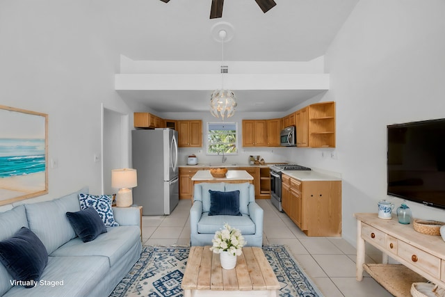 living room featuring lofted ceiling, light tile patterned flooring, and ceiling fan with notable chandelier