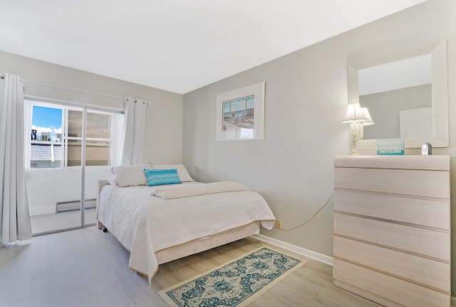 bedroom with baseboard heating and light wood-type flooring