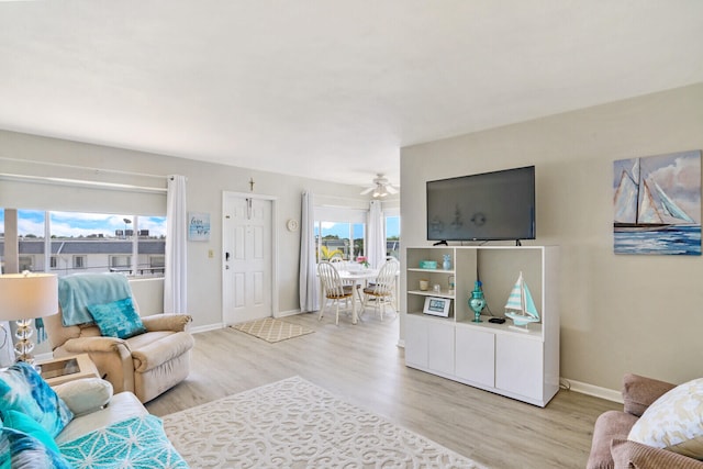 living room featuring a wealth of natural light, ceiling fan, and light hardwood / wood-style floors