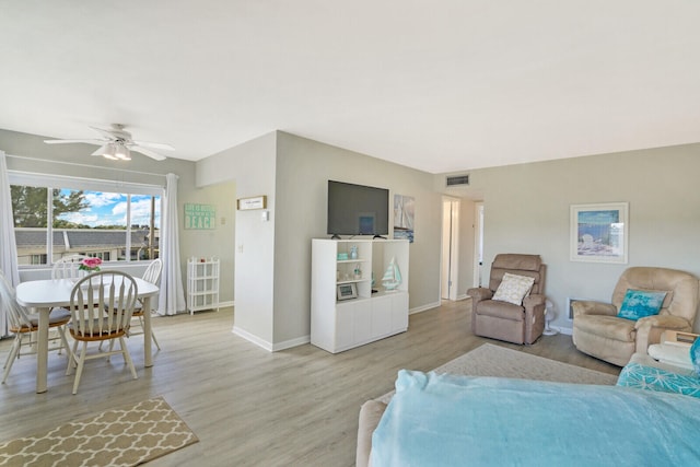 living room featuring ceiling fan and light hardwood / wood-style flooring