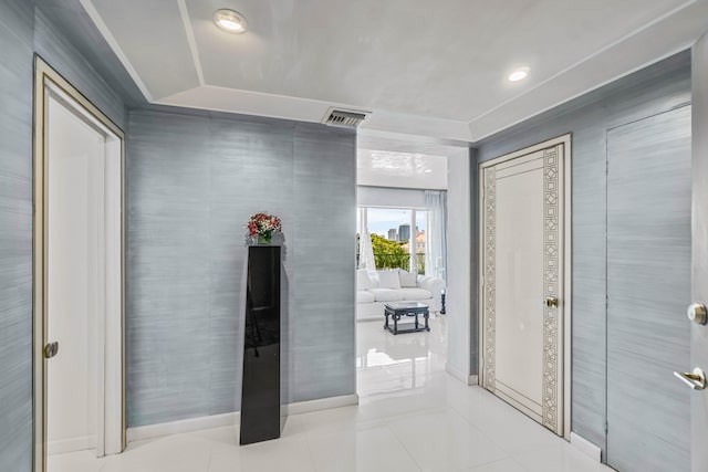 hallway with tile walls and light tile patterned flooring