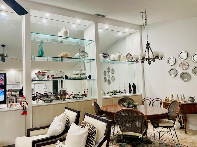 interior space featuring ceiling fan with notable chandelier, lofted ceiling, and tile patterned floors