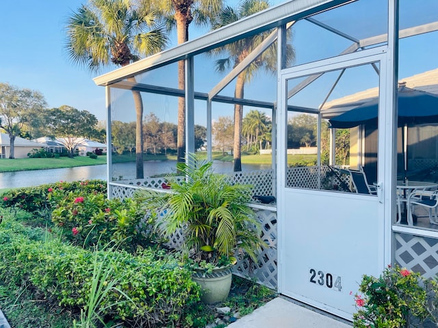 view of patio featuring a water view and a lanai