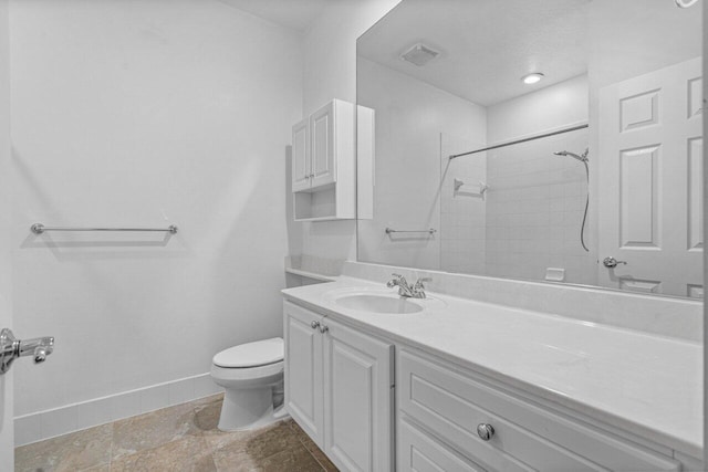 bathroom with baseboards, visible vents, toilet, a tile shower, and vanity