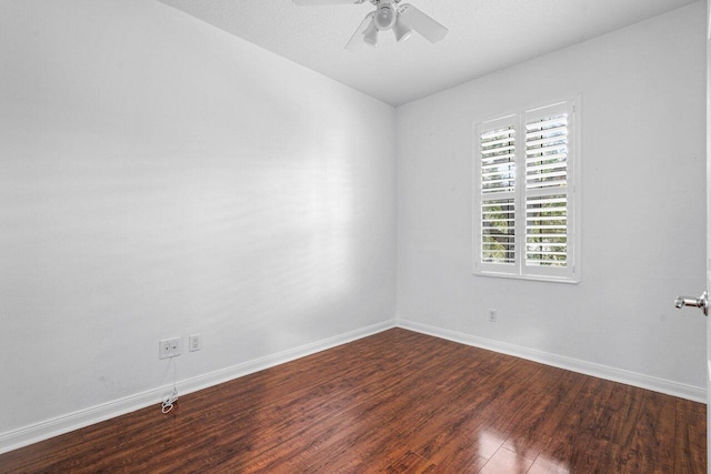 spare room featuring dark wood-style floors, baseboards, and a ceiling fan