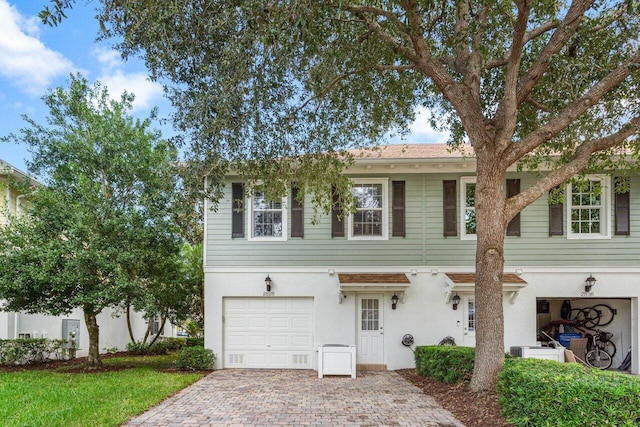 view of front of home with a garage, decorative driveway, and stucco siding